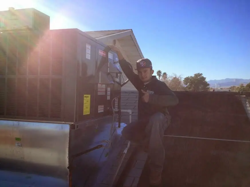 HVAC technician performing AC Tune-Up on a rooftop unit in Madera Acres